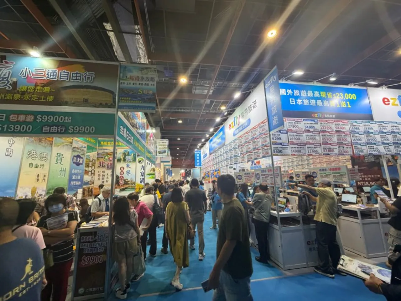 台湾の旅行展の会場。通路の両側にブースが並び、来場者が通路を歩いている