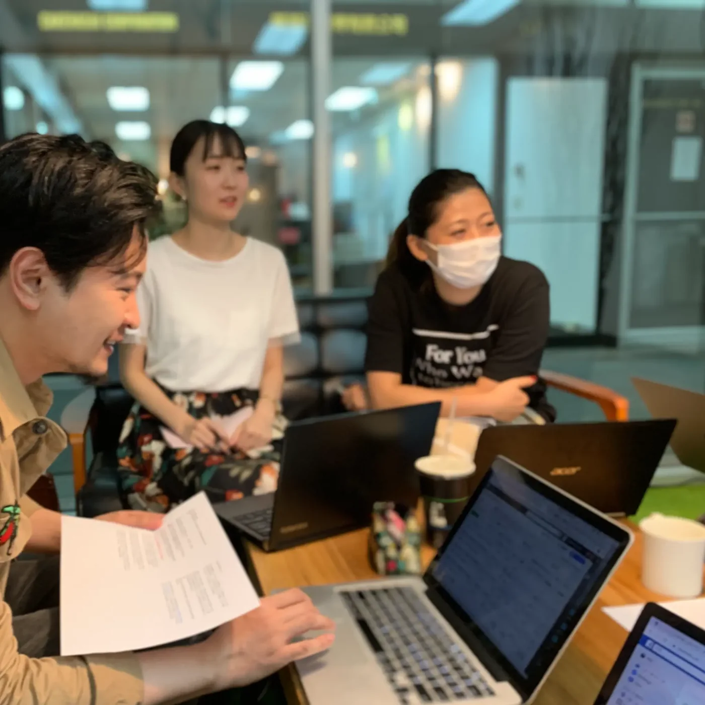 四位成員圍著筆電一起討論