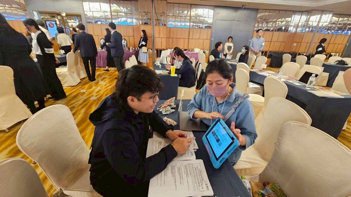 在展覽會場的沙發上,邊看平板邊洽談