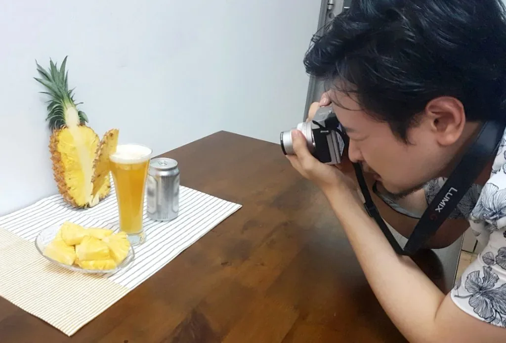 在桌上拍攝鳳梨與啤酒的商品照