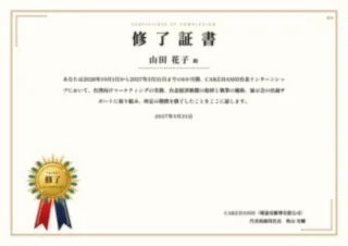 金のメダルと飾り枠が入った修了証書の見本